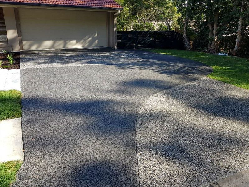 Exposed aggregate driveway curving to a garage