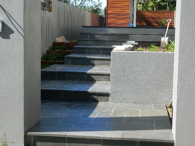 Bluestone-tiled steps beside a rendered wall