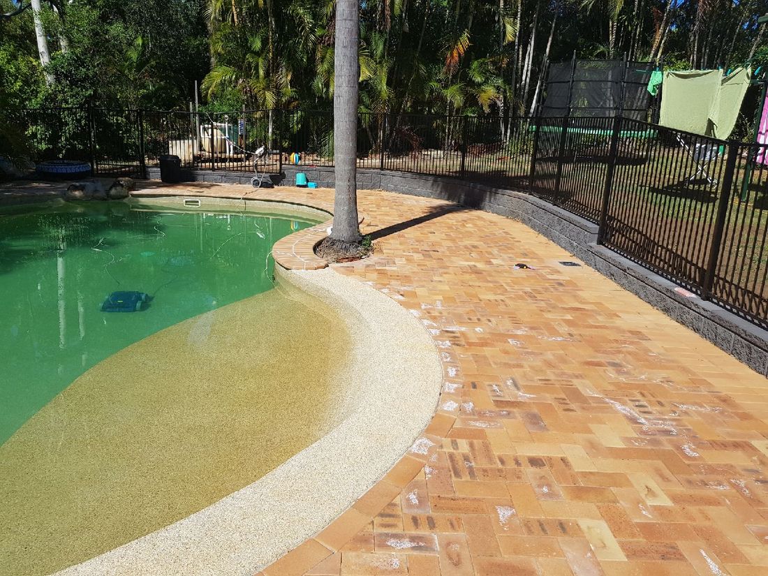 Pool with a herringbone-paved surround and pebble beach entry