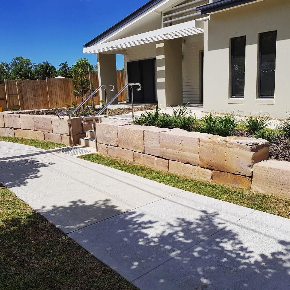 Sandstone block retaining wall and garden bed along a front path
